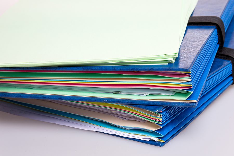 Blue Files Office, stack of contracts to show Manual Contract Processing